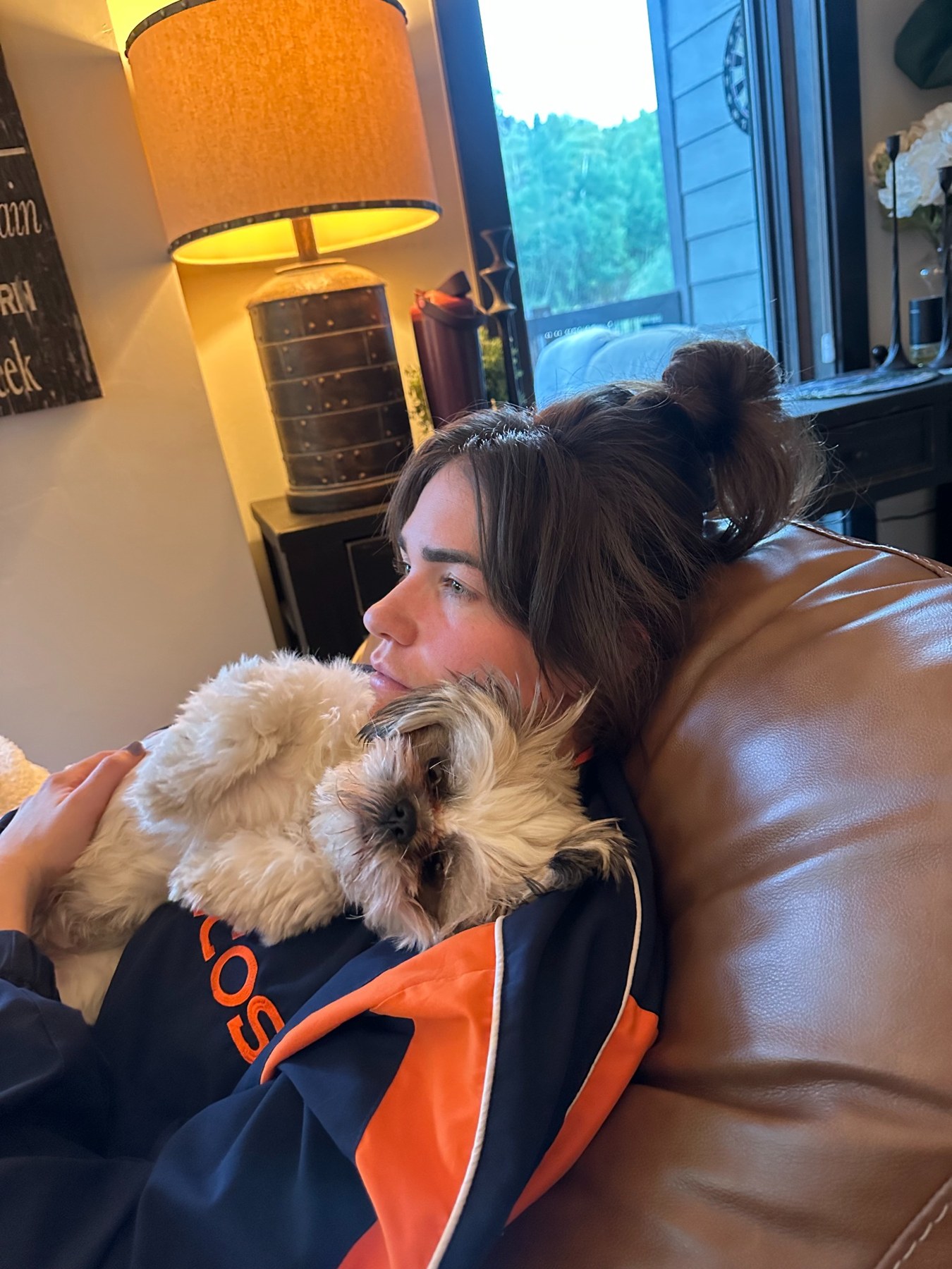 Morgan relaxing in a Broncos jersey with a dog