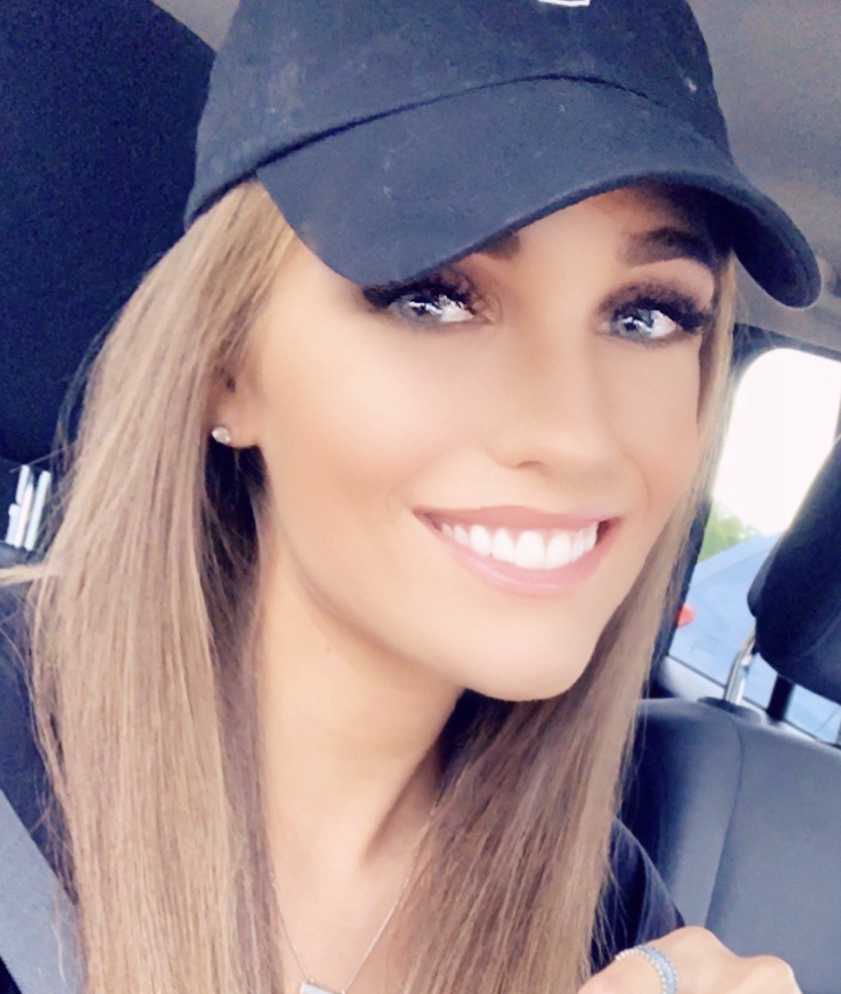 Morgan smiling in her signature black baseball cap