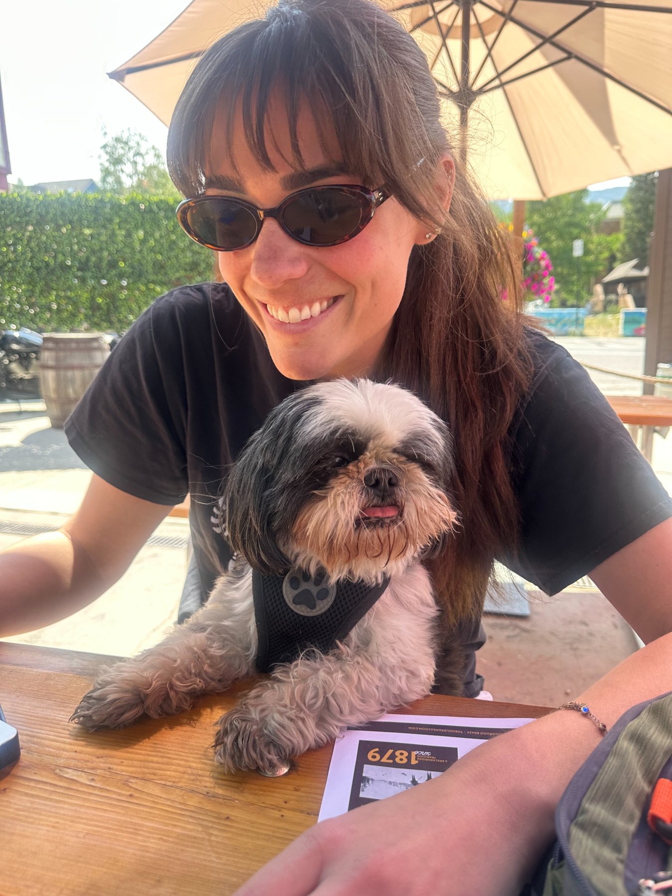 Morgan smiling with a dog on a sunny patio