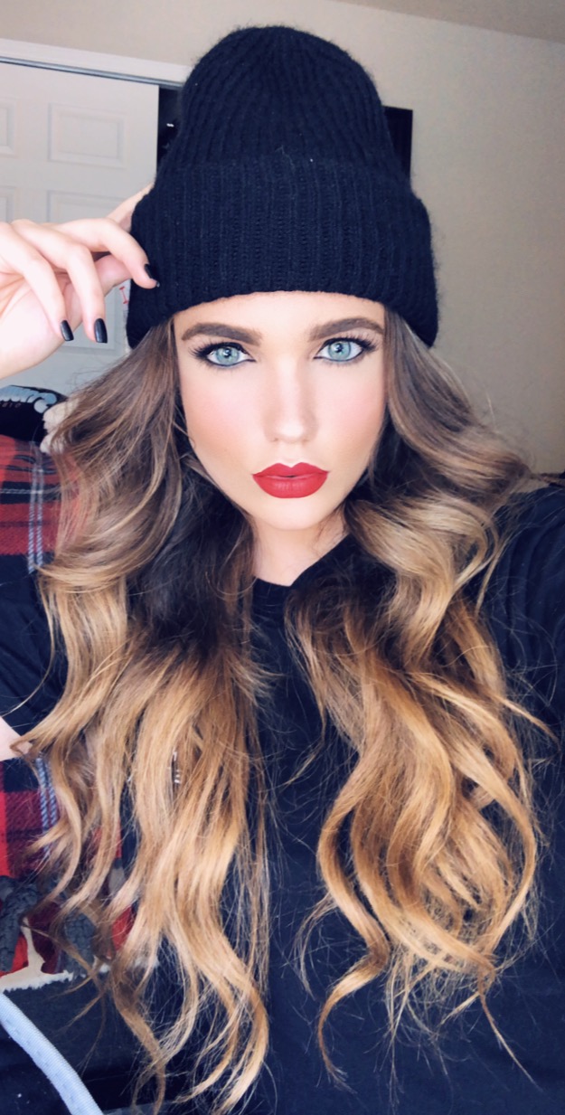 Morgan wearing a black knit beanie and red lipstick